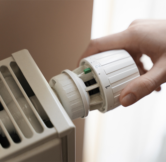 Un radiateur à eau aillant était installé par un plombier qui se fait tourner par une main pour chauffer la maison.